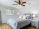 Bright bedroom features wood flooring, a ceiling fan, and light gray walls and trim at 910 Maple St # A & B, New Smyrna Beach, FL 32169