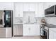 Bright kitchen with stainless steel appliances and white cabinets, countertops and backsplash at 910 Maple St # A & B, New Smyrna Beach, FL 32169