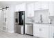 Bright, white kitchen featuring stainless steel appliances and a modern barn door entrance at 910 Maple St # A & B, New Smyrna Beach, FL 32169