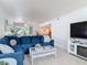 A cozy living room featuring a comfortable blue sofa, beachy decor, and lots of natural light at 910 Maple St # A & B, New Smyrna Beach, FL 32169