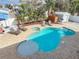 Aerial view of a refreshing pool area surrounded by lush landscaping and a spacious patio with lounge chairs at 910 Maple St # A & B, New Smyrna Beach, FL 32169