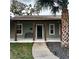 Inviting front porch with stained columns, a black front door, a bench and nice landscaping at 956 Tall Pine Dr, Port Orange, FL 32127