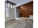 Well-lit living room featuring light gray floors, a decorative wood paneled accent wall, and a modern light fixture at 956 Tall Pine Dr, Port Orange, FL 32127