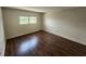 Bright bedroom featuring hardwood floors and natural light through the window at 101 N Riverside Dr # 2090, New Smyrna Beach, FL 32168