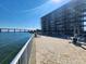 Exterior view of a waterfront condo building with a pool, patio furniture, and bridge in the background at 101 N Riverside Dr # 2090, New Smyrna Beach, FL 32168