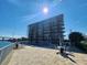 Exterior view of the condominium complex with a pool and outdoor seating area, all set against a blue sky at 101 N Riverside Dr # 2090, New Smyrna Beach, FL 32168
