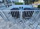Exterior view of two air conditioning units behind a fenced-in area with a stone paver ground at 101 N Riverside Dr # 2090, New Smyrna Beach, FL 32168