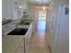 Kitchen with white appliances and cabinets leading to a living room with sliding glass doors to the balcony at 101 N Riverside Dr # 2090, New Smyrna Beach, FL 32168