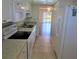 Galley kitchen featuring stainless steel appliances and view to living room at 101 N Riverside Dr # 2090, New Smyrna Beach, FL 32168