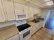 Functional kitchen featuring white appliances, ample cabinet space, and practical layout at 101 N Riverside Dr # 2090, New Smyrna Beach, FL 32168