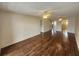 Open living room with dark hardwood floors, ceiling fans, and multiple entryways at 101 N Riverside Dr # 2090, New Smyrna Beach, FL 32168