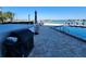 Community pool deck with a grill area, tables, and lounge chairs with waterfront views at 101 N Riverside Dr # 2090, New Smyrna Beach, FL 32168