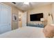 Comfortable bedroom features a large flat screen television and a surfboard for decoration at 105 Azalea Cir, New Smyrna Beach, FL 32168