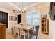 An elegant dining room showcases a wooden table with stylish chairs, a chandelier, and large windows for natural light at 105 Azalea Cir, New Smyrna Beach, FL 32168