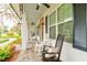 Inviting front porch with comfortable seating and a view of the landscaped yard at 105 Azalea Cir, New Smyrna Beach, FL 32168