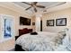 A comfortable bedroom features a decorative ceiling fan, TV, dresser, and sliding glass doors to the outdoors at 105 Azalea Cir, New Smyrna Beach, FL 32168