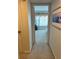 Neutral hallway leading to a carpeted bedroom with natural light at 1111 Hill St # U27, New Smyrna Beach, FL 32169