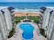 Aerial view of condo complex with pool, ocean views, and lounge chairs at 1275 Ocean Shore Blvd # 5050, Ormond Beach, FL 32176