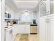 Bright kitchen features white cabinetry, tile floors, stainless steel dishwasher, and natural light at 1275 Ocean Shore Blvd # 5050, Ormond Beach, FL 32176