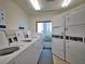 On-site laundry facility with multiple high-efficiency washers and dryers and natural light from a window at 1275 Ocean Shore Blvd # 5050, Ormond Beach, FL 32176