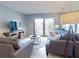 Comfortable living room with balcony access, stylish furnishings, and a large flatscreen television at 1275 Ocean Shore Blvd # 5050, Ormond Beach, FL 32176