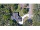 Birds-eye view of a home with dark roof, light colored circular driveway, and lush surrounding greenery at 1350 Scarlett Trl, New Smyrna Beach, FL 32168