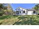 Spacious backyard with a large lawn and rear view of the home with screened in porch at 1350 Scarlett Trl, New Smyrna Beach, FL 32168