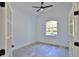 Well-lit bedroom with light walls, wood-look tile, a ceiling fan, and a window at 1350 Scarlett Trl, New Smyrna Beach, FL 32168