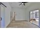 Spacious bedroom with sliding glass doors to the lanai and wood-look flooring, white trim and walls at 1350 Scarlett Trl, New Smyrna Beach, FL 32168