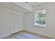 Bright bedroom featuring wood-look tile flooring, a window, and a closet at 1350 Scarlett Trl, New Smyrna Beach, FL 32168