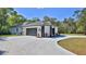 Beautiful home exterior featuring a three car garage, well-kept lawn, and paved driveway at 1350 Scarlett Trl, New Smyrna Beach, FL 32168
