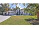 Beautiful front exterior with white stucco, black accents, arched windows, and a well-manicured green lawn at 1350 Scarlett Trl, New Smyrna Beach, FL 32168