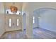 Open foyer features elegant tile floors, bright white walls, arched doorways, and an eye-catching light fixture at 1350 Scarlett Trl, New Smyrna Beach, FL 32168