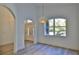 Bright room featuring tile floors, arched doorway, large window, pendant light, and white walls at 1350 Scarlett Trl, New Smyrna Beach, FL 32168