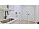 Well-lit laundry room featuring new cabinets, black faucet, and utility sink at 1350 Scarlett Trl, New Smyrna Beach, FL 32168