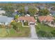 An aerial view of this property featuring a well-manicured lawn, mature trees, and a paved driveway at 15 Katrinas Dr, Ormond Beach, FL 32174