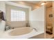 Bathroom featuring a bathtub, toilet, a block window, and decorative accessories on the side of the tub at 15 Katrinas Dr, Ormond Beach, FL 32174