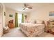 Cozy bedroom with a ceiling fan, closet, carpet, and a bed with floral comforter next to a bright window at 15 Katrinas Dr, Ormond Beach, FL 32174