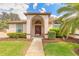 Elegant front entryway showcases an arched doorway, complemented by well-maintained greenery and a window at 15 Katrinas Dr, Ormond Beach, FL 32174
