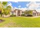 Inviting home with a well-manicured lawn, complemented by tropical palm trees and sculpted shrubbery at 15 Katrinas Dr, Ormond Beach, FL 32174