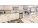 Kitchen featuring stainless steel dishwasher, white cabinets, granite countertops, and an open design to the dining area at 15 Katrinas Dr, Ormond Beach, FL 32174