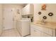 Functional laundry room with washer, dryer, sink, and ample storage cabinets at 15 Katrinas Dr, Ormond Beach, FL 32174