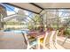 Screened-in patio featuring a dining table, comfortable seating, and a view of the pool at 15 Katrinas Dr, Ormond Beach, FL 32174