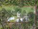 An aerial view showcases the expansive acreage, multiple buildings, and a sparkling pool, creating a private estate at 1715 Fern Park Dr, Port Orange, FL 32128