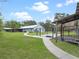 Expansive backyard featuring a well-maintained lawn, dog run and concrete pathway leading to the house at 1715 Fern Park Dr, Port Orange, FL 32128