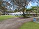 A large backyard with mature landscaping leads to the house, pool and horse paddock at 1715 Fern Park Dr, Port Orange, FL 32128