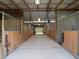 Well-maintained horse barn with spacious stalls, a center aisle, and overhead lighting at 1715 Fern Park Dr, Port Orange, FL 32128
