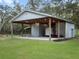 Functional metal barn featuring a large overhang, perfect for storage and other activities on a lush green lawn at 1715 Fern Park Dr, Port Orange, FL 32128
