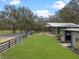 Exterior view of the barn surrounded by a green field, complemented by a classic black fence at 1715 Fern Park Dr, Port Orange, FL 32128