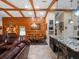Open concept dining area with wood-paneled walls and striking ceiling beams connects to the kitchen and living spaces at 1715 Fern Park Dr, Port Orange, FL 32128